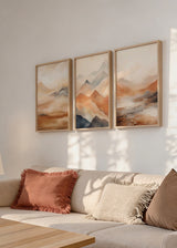 Set aus drei Wandbildern mit nebligen Bergen, sanften Tälern, Bronze-, Beige-, Sand- und Anthrazittönen, im klaren Natur- und Landschaftsstil gestaltet. Erhältlich auf kudeko.com