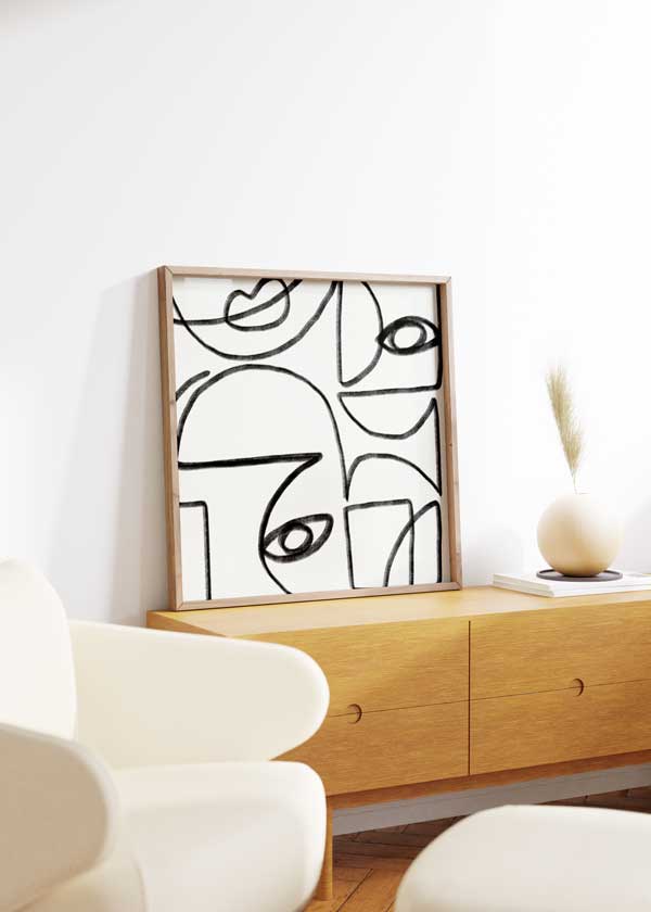 Tableau carré avec visages abstraits en lignes noires épaisses, yeux, profils et courbes sur fond blanc, dans un style abstrait contemporain. Disponible sur kudeko.com