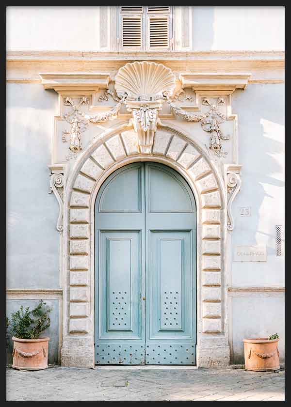 Cuadro de puerta romana azul suave con fachada clásica beige, relieves ornamentales, arco de piedra y macetas de terracota, de estilo fotográfico. Disponible en kudeko.com