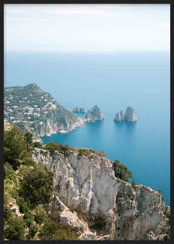 Cuadro de costa de Capri con acantilados blancos, mar azul intenso, vegetación mediterránea y farallones rocosos, de estilo fotográfico. Disponible en kudeko.com