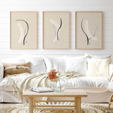 Conjunto de tres cuadros abstractos con formas en negro y blanco, fondo beige