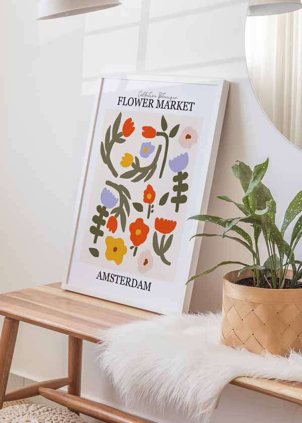 Cuadro de flores silvestres en tonos coral, amarillo, lila, rosa suave y verde oliva, con tipografía Flower Market Amsterdam y estilo floral moderno. Disponible en kudeko.com