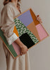 Tableau encadré avec composition abstraite de blocs irréguliers en rose, lilas, orange, vert sauge, beige et noir, avec motif organique central et style abstrait contemporain. Disponible sur kudeko.com
