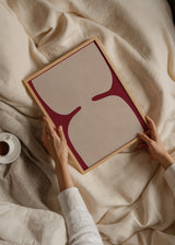 Cuadro decorativo de estilo abstracto y minimalista colocado en salón, formas abstractas beige sobre fondo rojo, modelo Minimalist Beige Shapes