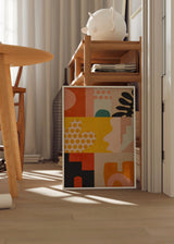 Tableau encadré avec composition abstraite de formes organiques, pois, arches et blocs géométriques en jaune moutarde, terracotta, rose poudré, noir et vert bleuté, dans un style rétro contemporain. Disponible sur kudeko.com