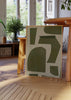 Gerahmtes Wandbild mit unregelmäßigen geometrischen Formen in Olivgrün auf beigem Hintergrund, ausgewogener abstrakter Komposition und zeitgemäßem Stil in Naturtönen. Erhältlich auf kudeko.com