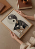 Cuadro decorativo de estilo blanco_y_negro y minimalista colocado en salón, ilustración surrealista en acuarela de figura femenina, modelo Coastal Art Brown V
