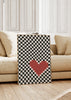 Cuadro decorativo de estilo blanco_y_negro y minimalista colocado en salón, corazón pixelado sobre patrón ajedrezado, modelo Pixel Heart