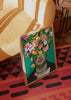 Quadro com retrato feminino a preto e branco, flores rosa, folhas tropicais verdes, ave multicolorida, lábios vermelhos, fundo turquesa e estilo floral contemporâneo. Disponível em kudeko.com