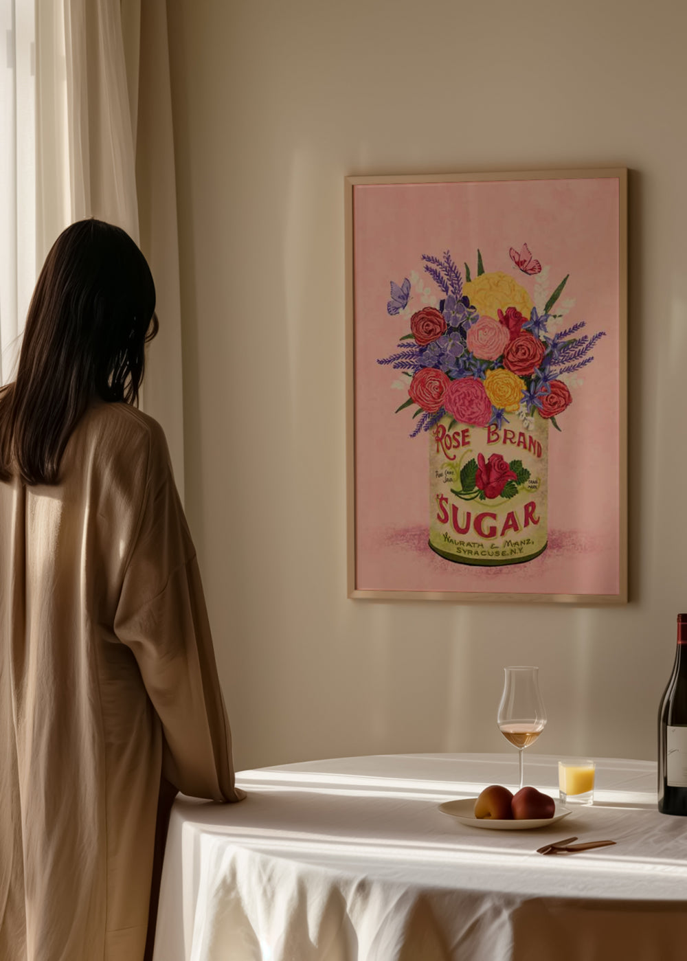 Quadro emoldurado com ramo de flores rosas, violetas e amarelas numa lata vintage, sobre fundo rosa suave, com folhas verdes, pequenas borboletas e estilo floral romântico. Disponível em kudeko.com