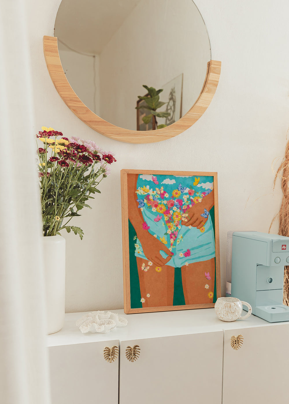 Quadro emoldurado com figura feminina, calções turquesa, flores multicoloridas, borboletas, fundo azul e estilo de ilustração com presença decorativa. Disponível em kudeko.com