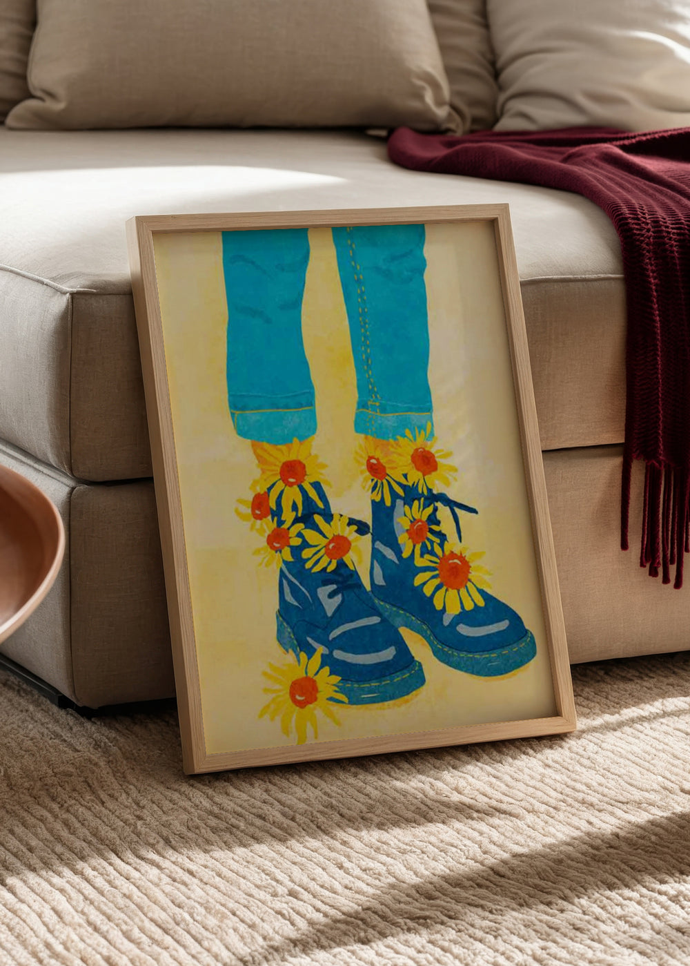 Quadro com botas azuis, girassóis amarelos de centro laranja, calças turquesa, fundo creme luminoso e estilo de ilustração gráfica contemporânea. Disponível em kudeko.com