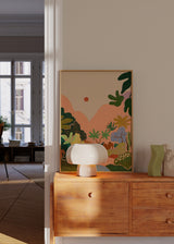 Tableau avec paysage tropical, montagnes roses, rivière bleue, cascade claire, feuillage vert, figures humaines au repos et style illustration aux tons pastel. Disponible sur kudeko.com
