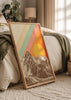 Gerahmtes Wandbild mit verschneiten Bergen in Sepiatönen, großer gelber Sonne und diagonalen Streifen in Orange, Koralle, Aqua und Creme im Vintage-Stil. Erhältlich auf kudeko.com