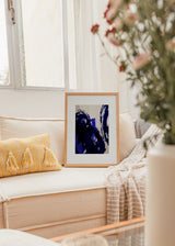 Gerahmtes Wandbild mit abstrakter Komposition aus überlagerten geschwungenen Formen in Elektroblau, Marineblau, Schwarz und hellem Beige, im zeitgenössischen abstrakten Stil. Erhältlich auf kudeko.com