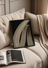 Quadro abstrato emoldurado com formas curvas amplas em tons de bege e areia sobre fundo preto, composição fluida de estilo contemporâneo para parede. Disponível em kudeko.com