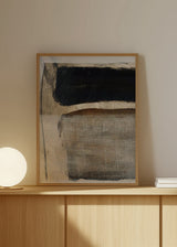 Gerahmtes Wandbild mit abstrakter Komposition aus schwarzen, steingrauen und beigen Flächen, dezenten braunen Akzenten, hellem strukturiertem Hintergrund und minimalistischem Stil. Erhältlich auf kudeko.com