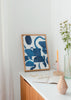 Wandbild mit abstrakter Komposition aus geschwungenen Formen und unregelmäßigen Blöcken in Indigo blau, Petrolblau und Türkis auf weißem Hintergrund, im modernen abstrakten Stil. Erhältlich auf kudeko.com