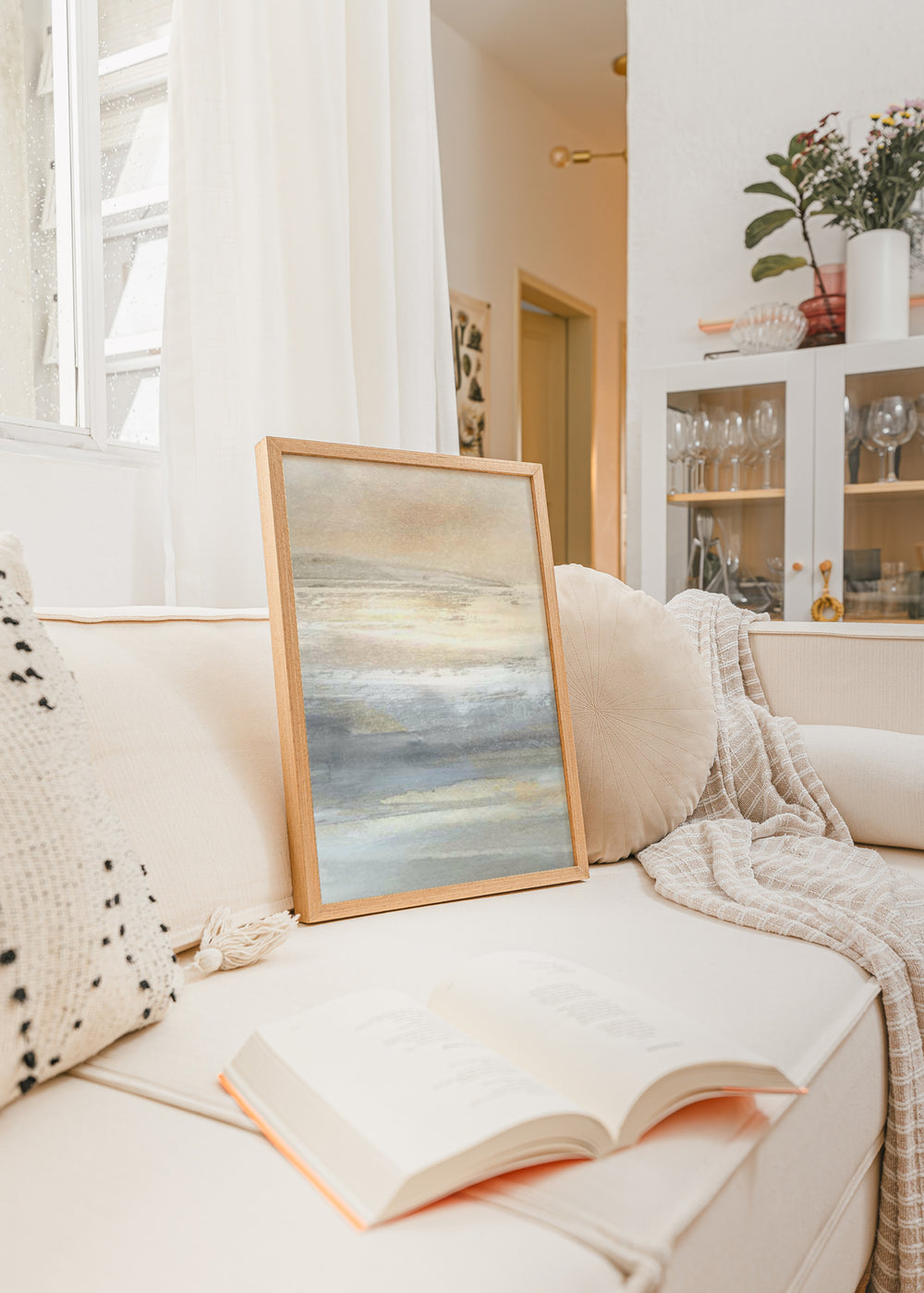 Tableau encadré représentant un paysage abstrait aux horizons diffus, en beige, crème, gris bleuté et touches dorées, dans un style abstrait apaisant. Disponible sur kudeko.com