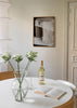 Wandbild mit abstrakter Komposition in Beige, Off-White, Dunkelbraun und Schwarz, überlagerten Formen, hellem Diagonalband und feinen geschwungenen Linien im modernen Stil. Erhältlich auf kudeko.com