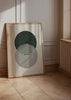 Wandbild mit zwei überlappenden Kreisen in Dunkelgrün und Taupegrau auf beigem Hintergrund, in minimalistischem geometrischem Stil mit klarer ausgewogener Komposition. Erhältlich auf kudeko.com