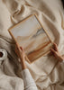 Wandbild mit diffusen Bergen im Nebel in Beige, Creme, Kupfer und Braun, im Natur- und Landschaftsstil mit ruhiger Komposition. Erhältlich auf kudeko.com