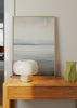 Tableau encadré avec paysage à horizon brumeux, nuages doux et bandes gris bleuté, blanc cassé et beige clair, dans un style nature et paysages apaisant. Disponible sur kudeko.com
