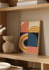 Tableau encadré avec demi-cercles, arcs concentriques et blocs géométriques en bleu profond, moutarde, rose poudré, crème et noir, dans un style rétro géométrique. Disponible sur kudeko.com