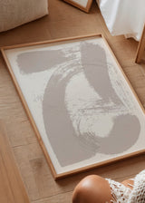 Tableau encadré avec formes abstraites courbes et aplats gestuels en greige doux sur fond blanc, dans un style abstrait contemporain et épuré. Disponible sur kudeko.com