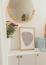 Tableau encadré avec silhouette de visage en ligne blanche continue sur forme organique beige, sable et gris doux, dans un style minimaliste et épuré. Disponible sur kudeko.com