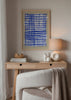 Gerahmtes Wandbild mit unregelmäßigem blauem Linienraster, weißer Mitte, beigem Hintergrund und geometrischem Stil für moderne Räume. Erhältlich auf kudeko.com
