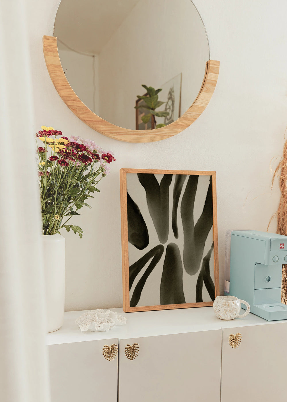 Tableau décoratif de style minimaliste en noir et blanc placé dans un salon, avec motif animalier abstrait en tons olive, modèle Animal Print Oliva. Disponible sur kudeko.com