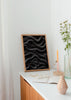 Tableau avec ondes abstraites en noir, gris et blanc, lignes fluides, effet de profondeur sur fond sombre et style abstrait contemporain. Disponible sur kudeko.com