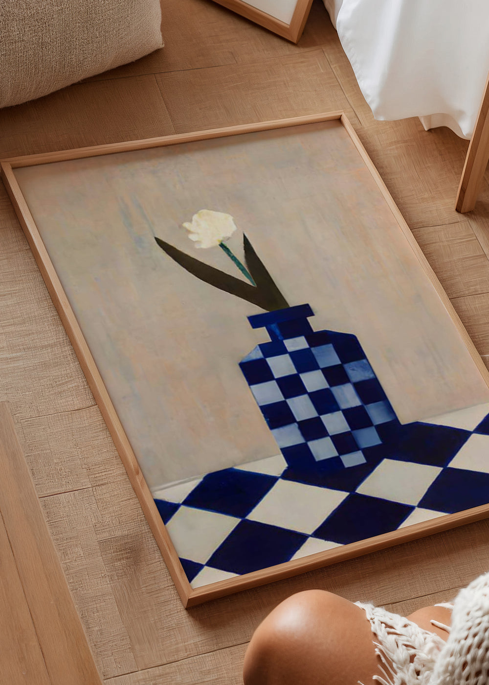 Tableau avec vase à carreaux bleus et blancs, fleur blanche, feuilles sombres, fond beige doux et style illustration contemporain. Disponible sur kudeko.com
