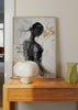 Quadro com figura feminina abstrata em preto, cinzento, branco e detalhes dourados, silhueta difusa e traços expressivos num estilo abstrato contemporâneo. Disponível em kudeko.com