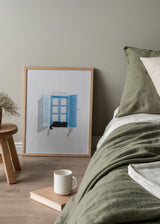Cuadro decorativo de estilo minimalista y blanco_y_negro colocado en salón, gato negro en ventana azul, modelo Gato en la ventana