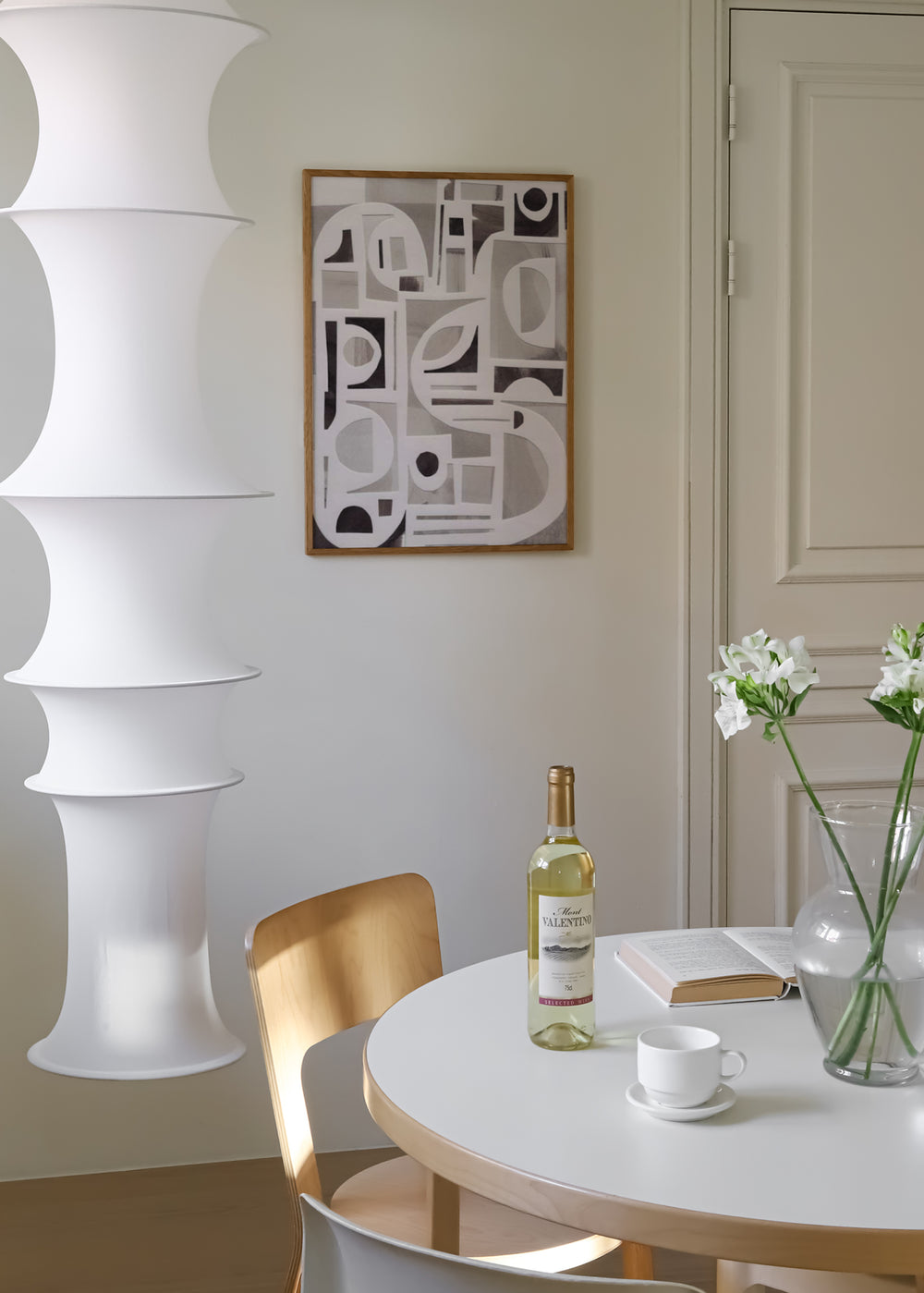 Quadro emoldurado com colagem de formas geométricas em branco, preto e cinzento, com arcos, círculos, semicírculos e blocos sobrepostos de estilo abstrato contemporâneo. Disponível em kudeko.com