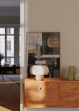 Gerahmtes abstraktes Wandbild mit überlagerten Blöcken in Schwarz, Weiß und Grau, feinen Linien, geometrischen Formen und goldenen Akzenten im zeitgenössischen Stil. Erhältlich auf kudeko.com