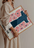 Tableau encadré avec Christ Rédempteur au centre, grandes fleurs roses, fond clair, détails typographiques noirs, tons bleu foncé et style illustration contemporaine. Disponible sur kudeko.com