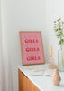 Tableau encadré avec la phrase COW GIRLS en grande typographie serif, fond rose doux, lettres rose clair et rouge, style à message moderne pour décoration murale. Disponible sur kudeko.com