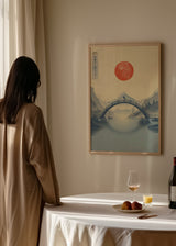 Cuadro decorativo de estilo minimalista y ilustración colocado en salón, paisaje japonés con sol rojo y puente, modelo Beneath the Scorching Sun