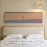 Cuadro decorativo de estilo minimalista y ilustración colocado en salón, figura solitaria frente al mar al atardecer, modelo La hora dorada