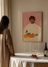 Cuadro decorativo de estilo minimalista y ilustración colocado en salón, mujer ilustrada con naranjas en tonos suaves, modelo The Woman With the Oranges