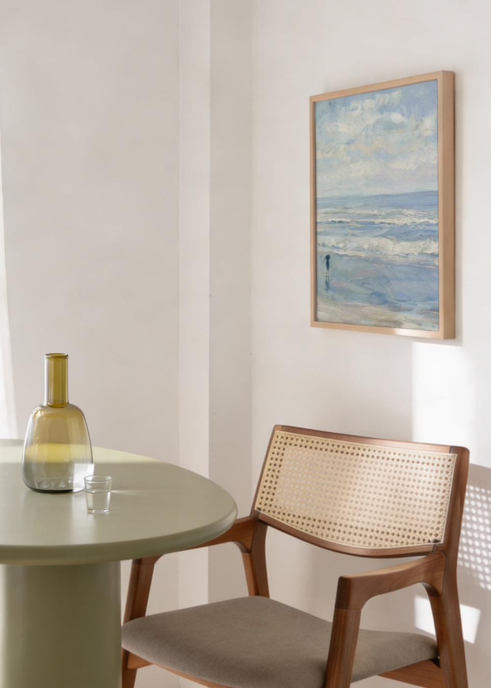 Gerahmtes Wandbild mit Strand, sanften Wellen, weitem bewölktem Himmel, einzelner Figur am Ufer, in Hellblau, Weiß und Grau, im Vintage-Stil. Erhältlich auf kudeko.com