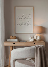 Tableau encadré avec les mots inhale exhale en calligraphie noire fine sur fond beige clair, style typographique épuré et ambiance minimaliste apaisante. Disponible sur kudeko.com
