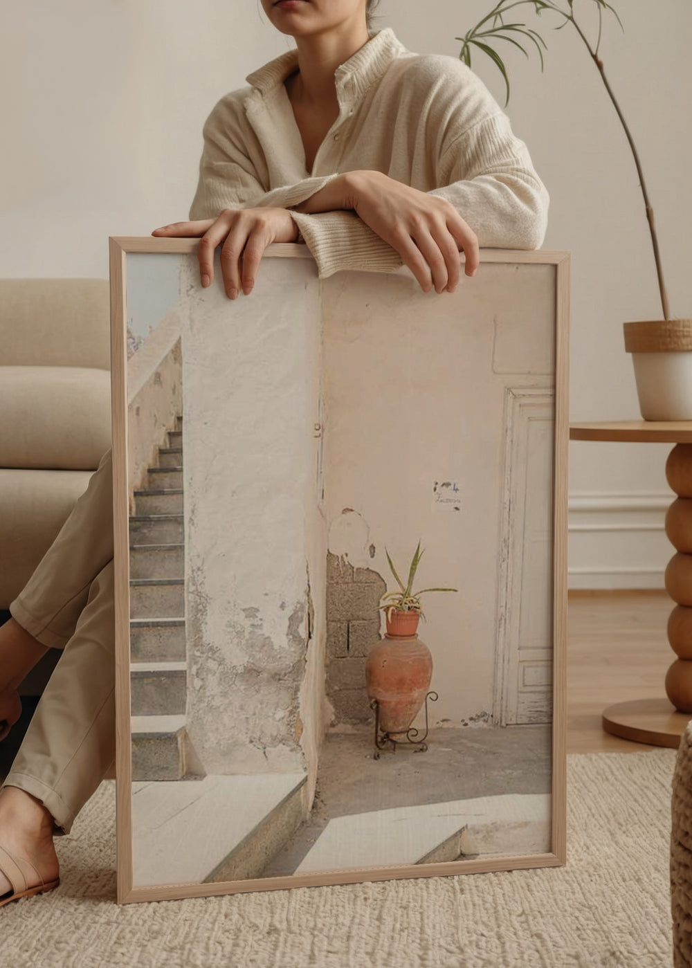 Wandbild einer mediterranen Ecke mit Steintreppe, gealterter weißer Wand, heller Tür, Terrakottagefäß, grüner Pflanze und fotografischem Stil in Creme-, Sand- und Ziegelfarben. Erhältlich auf kudeko.com