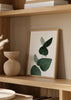 Quadro com ramo de eucalipto em tons de verde escuro sobre fundo claro, com estilo decorativo simples e natural. Disponível em kudeko.com