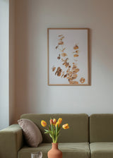 Gerahmtes Wandbild mit Eukalyptuszweigen in Gold, Beige und sanftem Kupfer auf hellem Hintergrund, im leichten botanisch-floralen Stil gestaltet. Erhältlich auf kudeko.com