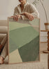 Cuadro decorativo de estilo minimalista y orgánico colocado en salón, composición geométrica abstracta en tonos verdes, modelo Green geometric shapes I