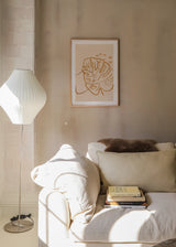 Quadro emoldurado com folhas tropicais sobrepostas em bege, areia e caramelo, linhas orgânicas, composição minimalista sobre fundo claro e estilo natural contemporâneo. Disponível em kudeko.com